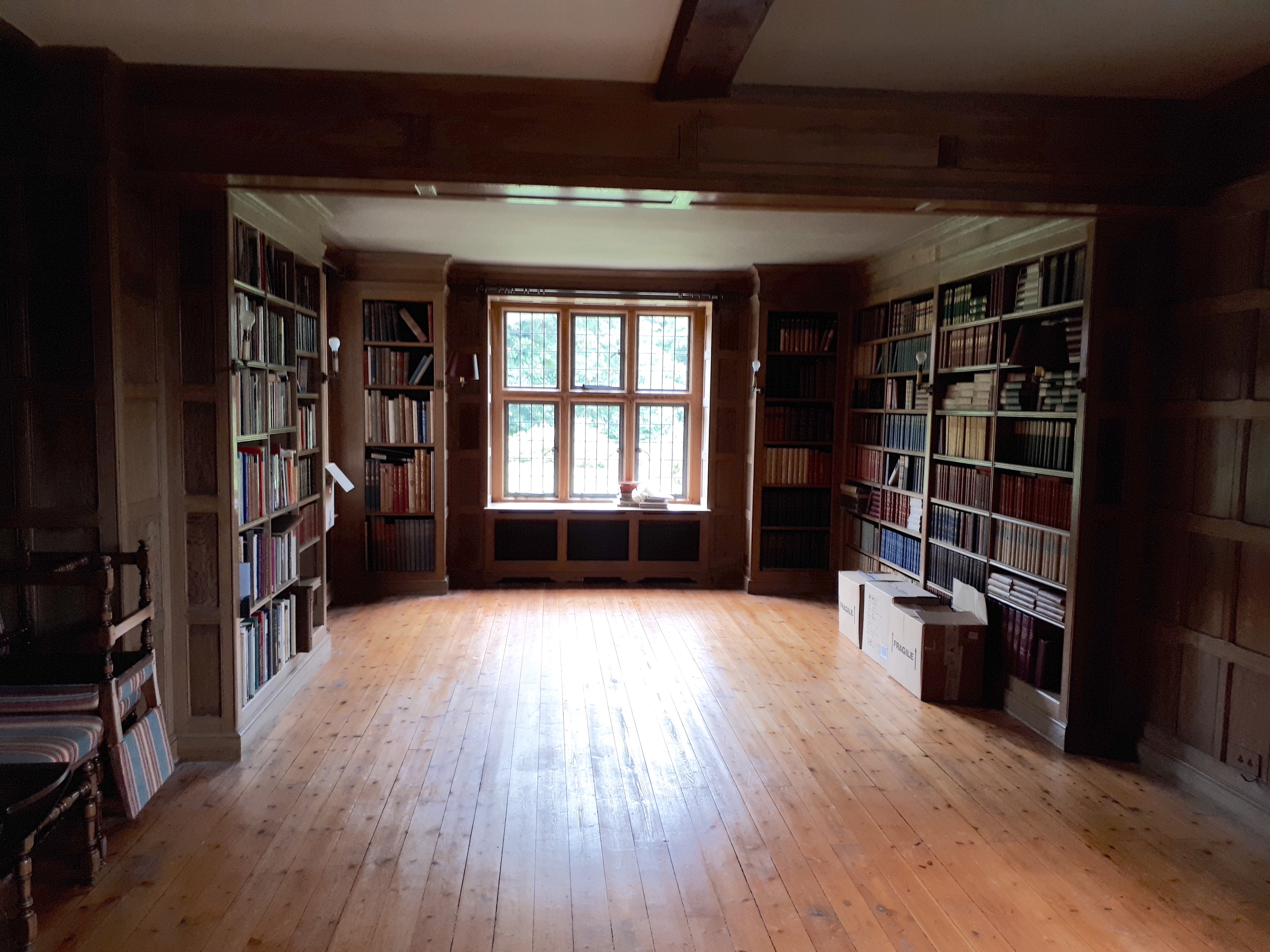 Three dismantled oak bookcases, formerly in the library at Plumpton Place, consisting of an ‘’L’’ shaped section, 455cm, the return 124cm; another ‘’L’’ section, 110cm, the return 68cm, and single section, 255cm, Overall